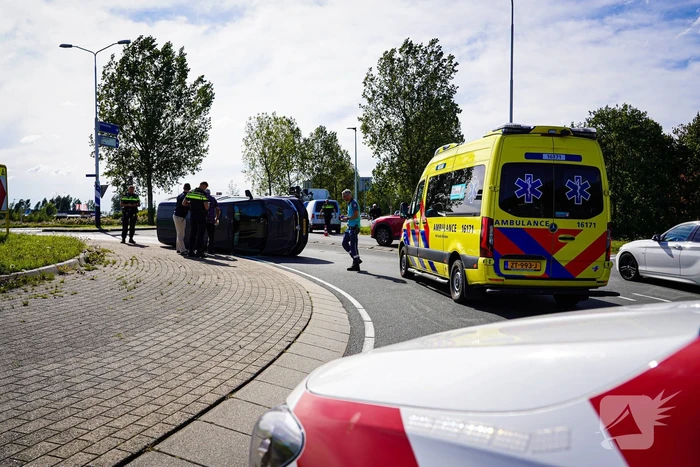 Bestelbus op zijn kant na botsing