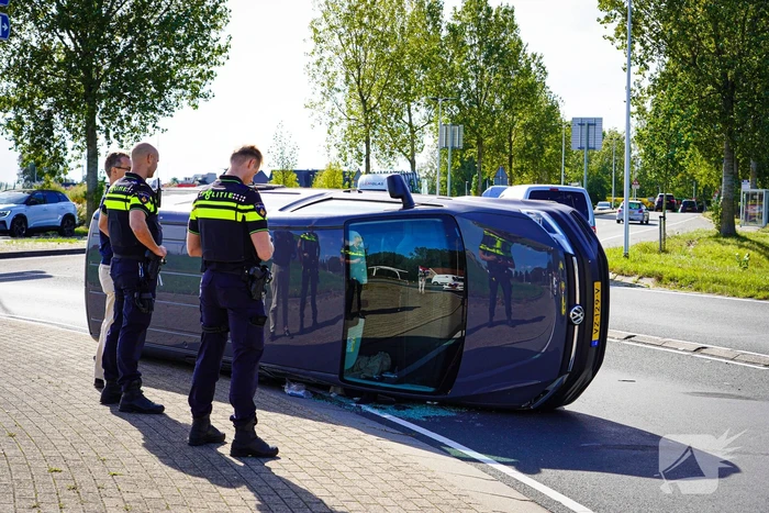 Bestelbus op zijn kant na botsing