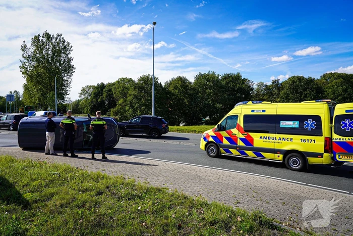 Bestelbus op zijn kant na botsing
