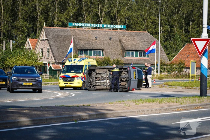 Bestelbus op zijn kant na botsing