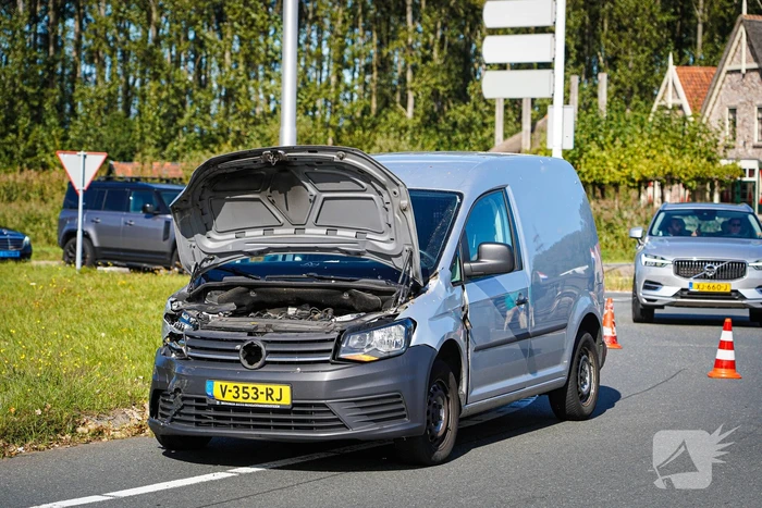 Bestelbus op zijn kant na botsing