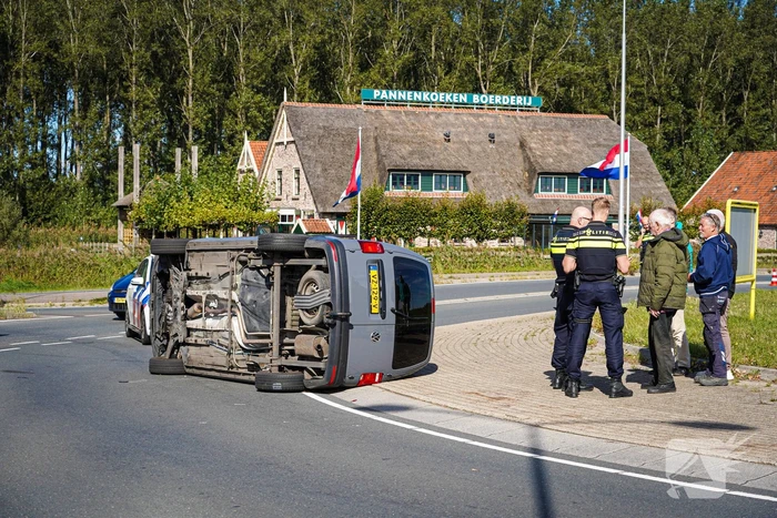Bestelbus op zijn kant na botsing