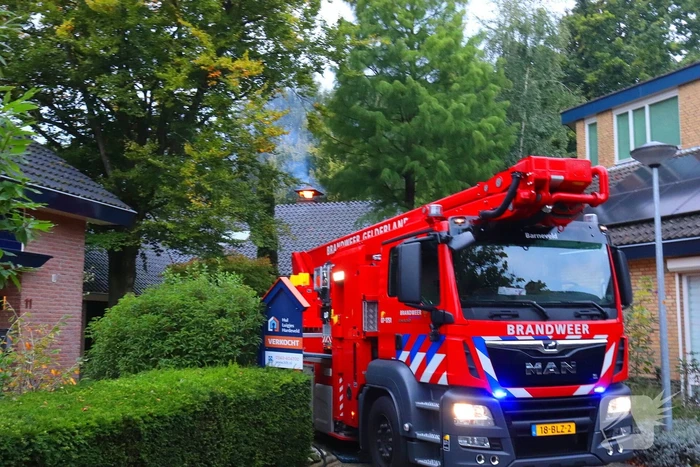 Vlammen slaan uit schoorsteen