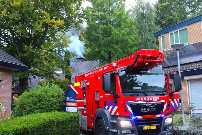 Vlammen slaan uit schoorsteen