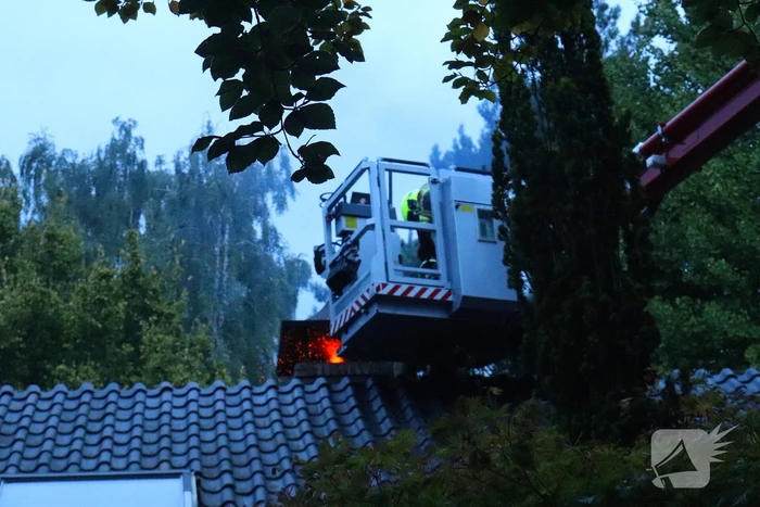 Vlammen slaan uit schoorsteen