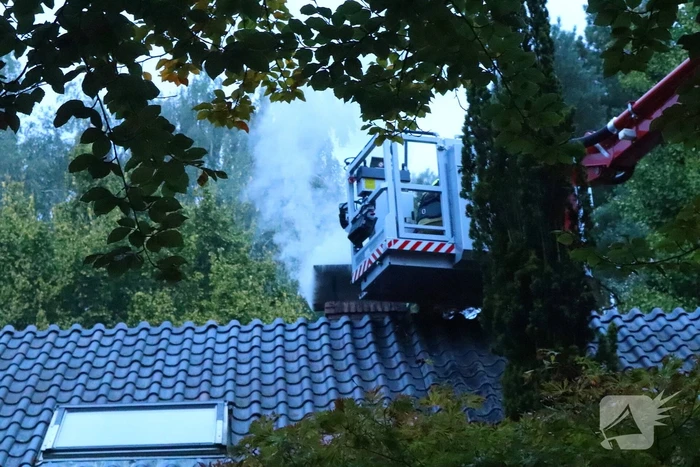 Vlammen slaan uit schoorsteen