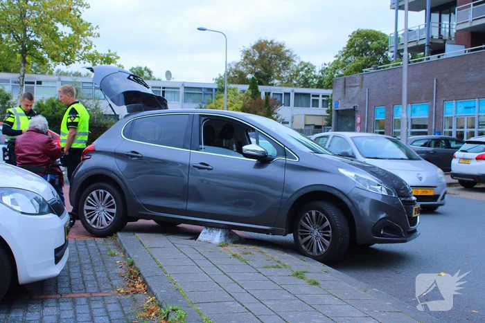 Automobilist vast op betonblok