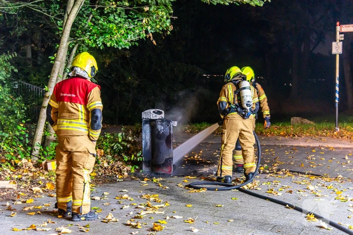 Brandweer blust brand in prullenbak