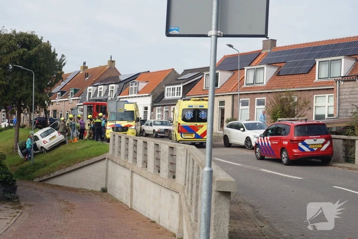 Auto van dijk gereden, bestuurder met spoed naar ziekenhuis