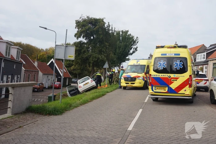 Auto van dijk gereden, bestuurder met spoed naar ziekenhuis