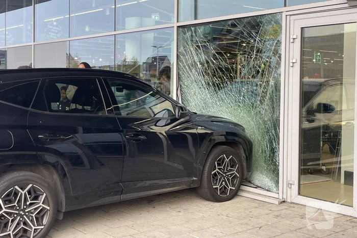 Automobilist ramt gevel supermarkt