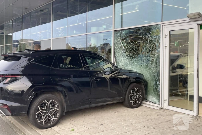 Automobilist ramt gevel supermarkt