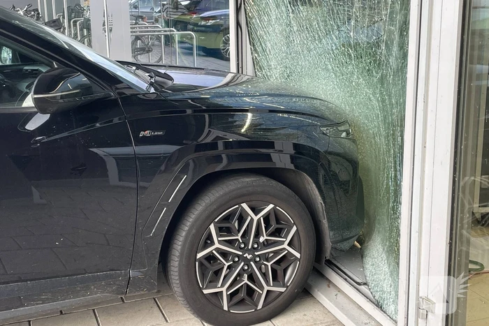 Automobilist ramt gevel supermarkt