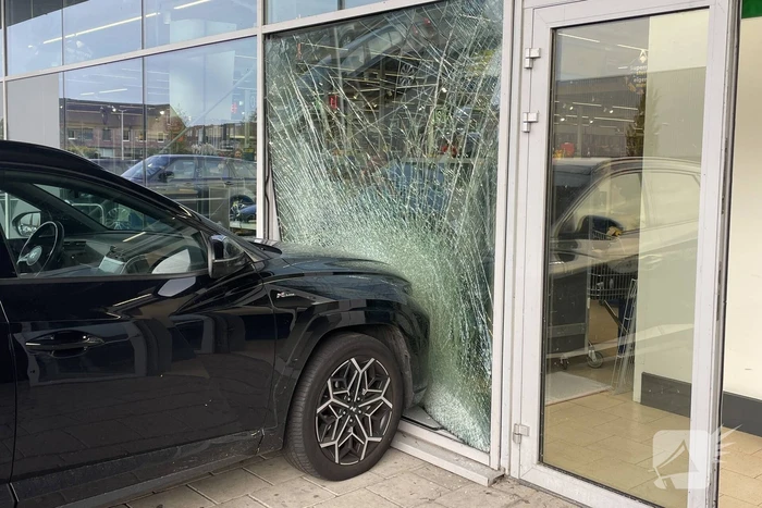 Automobilist ramt gevel supermarkt