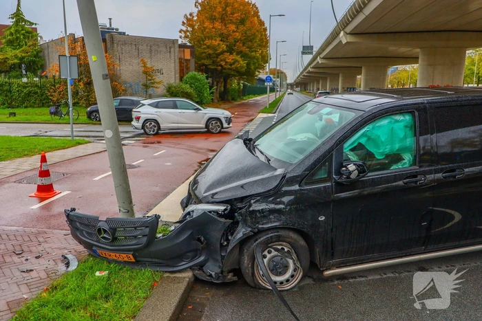 Bestelbus botst tegen lantaarnpaal