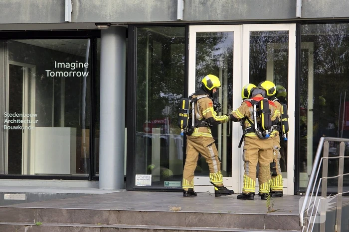 Kantoorpand brandt, rook uit bovenverdieping