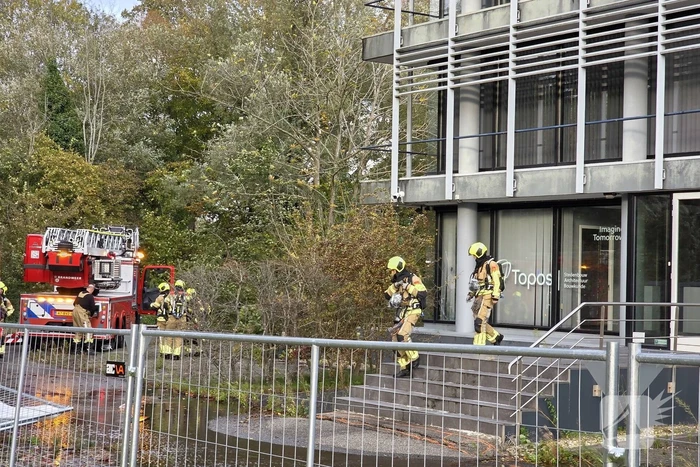 Kantoorpand brandt, rook uit bovenverdieping