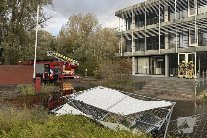Kantoorpand brandt, rook uit bovenverdieping