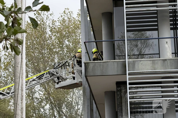 Kantoorpand brandt, rook uit bovenverdieping