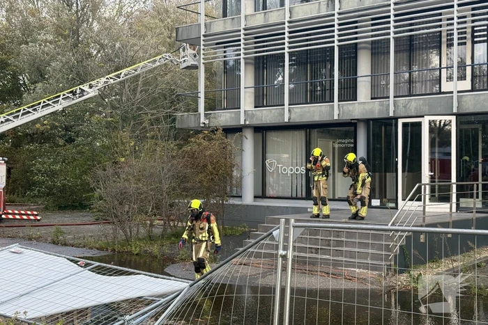 Kantoorpand brandt, rook uit bovenverdieping