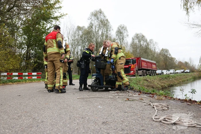 Man met scootmobiel te water