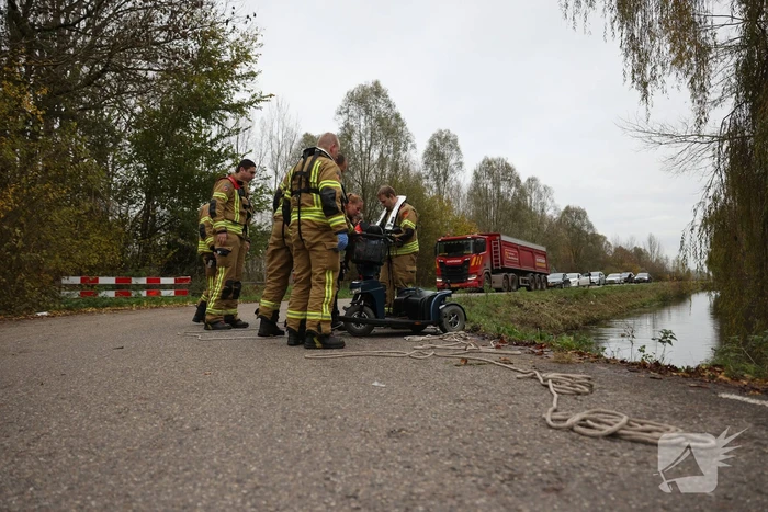 Man met scootmobiel te water