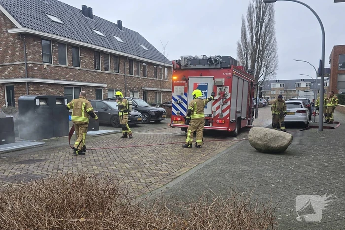 Container vat vlam door vuurwerk, omstanders doen bluspoging