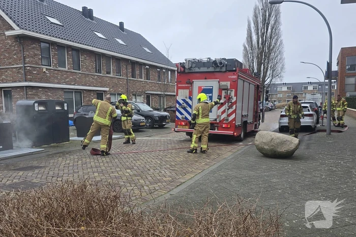 Container vat vlam door vuurwerk, omstanders doen bluspoging