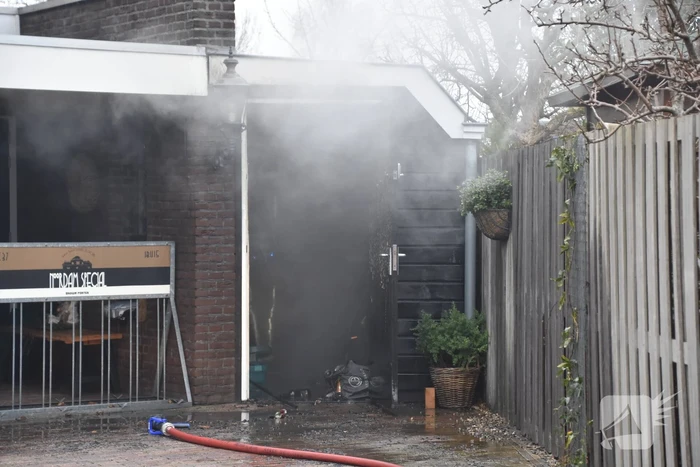 Zware rookwolken door containerbrand, garage aangetast