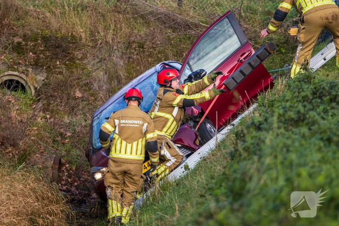 Auto op zijkant in greppel na ongeval