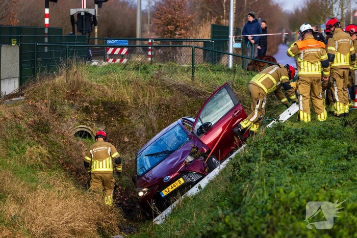 Auto op zijkant in greppel na ongeval