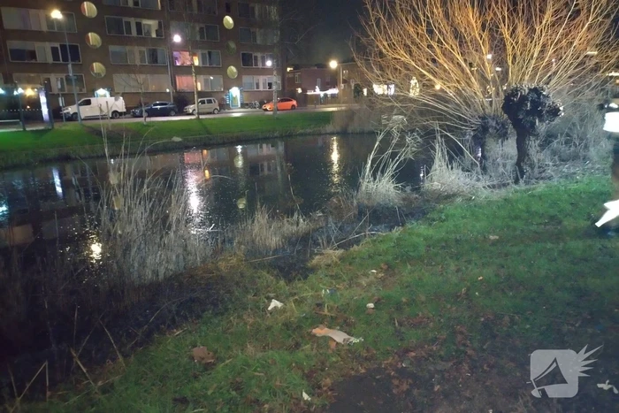 Brandweer blust brand langs sloot
