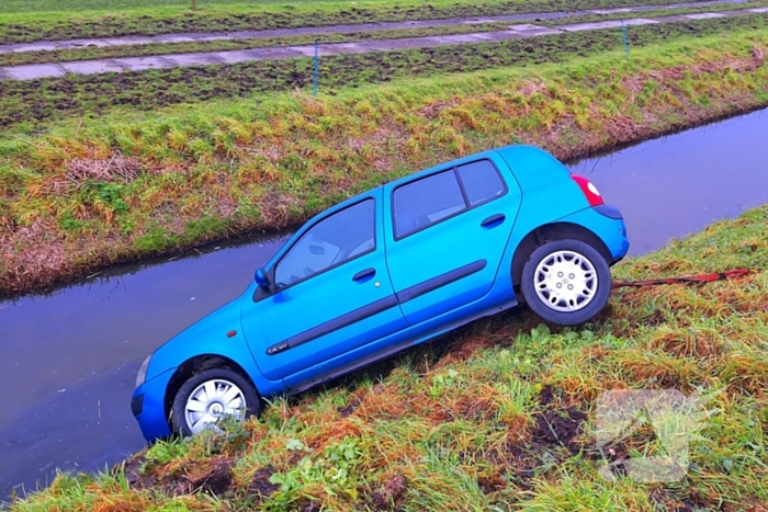 Auto te water door modderig wegdek