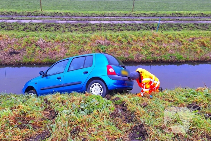 Auto te water door modderig wegdek