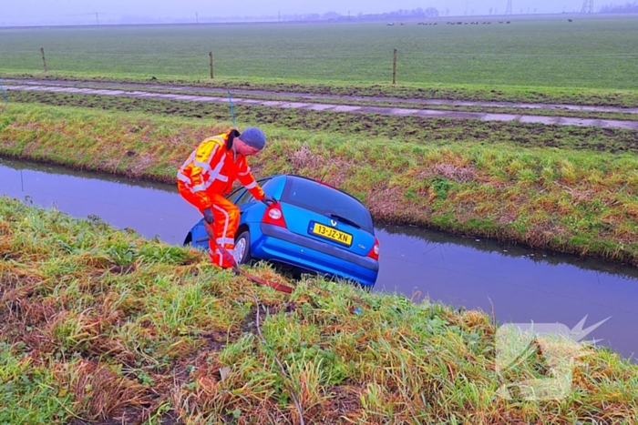 Auto te water door modderig wegdek