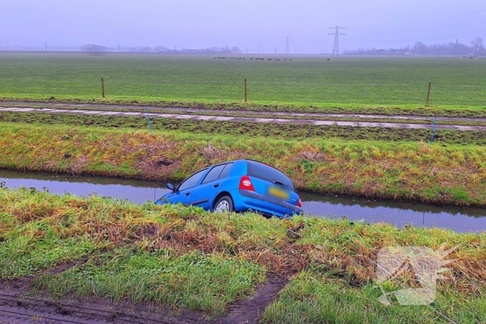 Auto te water door modderig wegdek