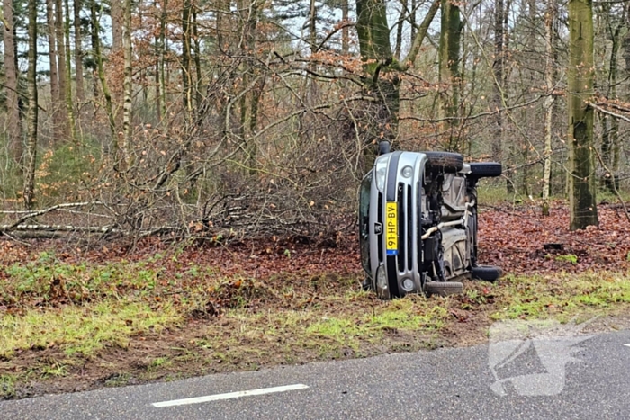 Auto belandt op zijkant naast weg