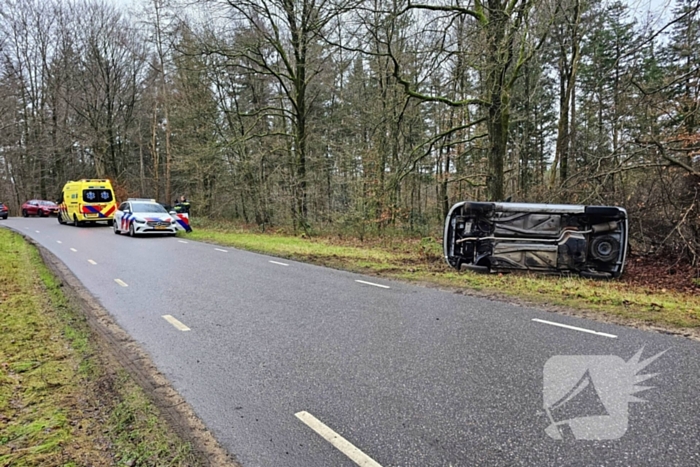 Auto belandt op zijkant naast weg
