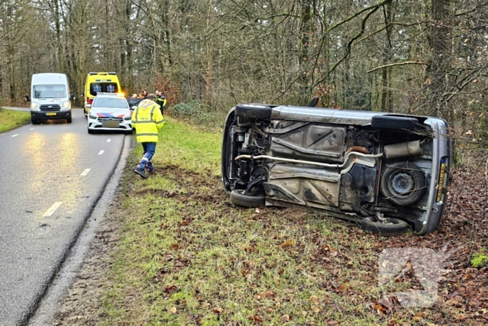 Auto belandt op zijkant naast weg