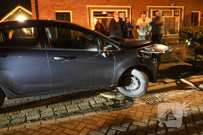 Automobilist ramt lantaarnpaal en kleine paal