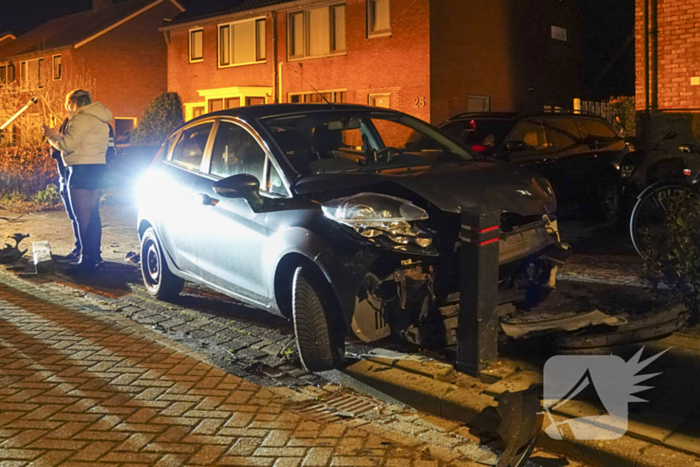 Automobilist ramt lantaarnpaal en kleine paal