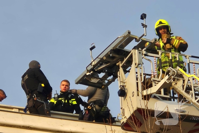 Man gooit voorwerpen van dak, politie team haalt man van dak