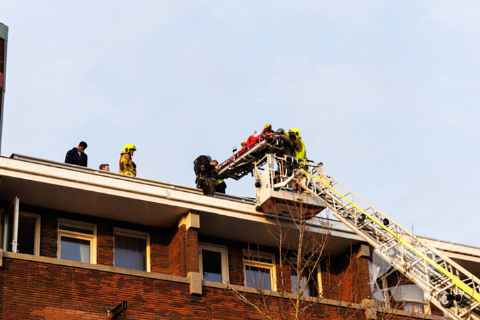 Man gooit voorwerpen van dak, politie team haalt man van dak
