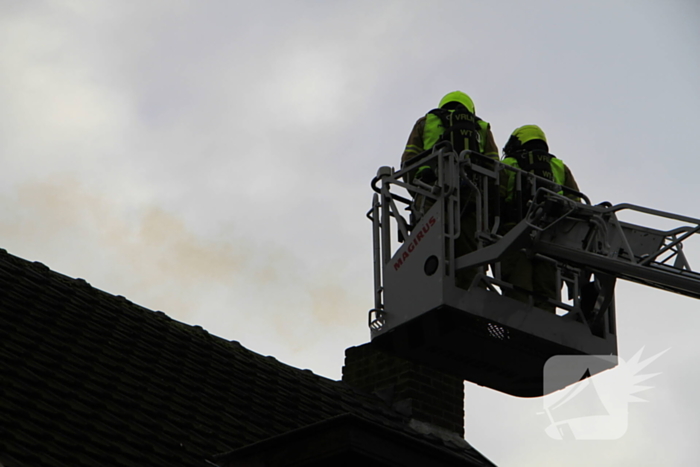 Brandweer controleer schoorsteen na brand