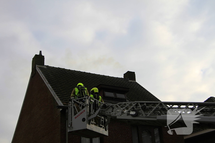 Brandweer controleer schoorsteen na brand