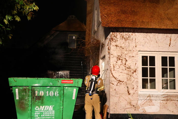 Bouwcontainer vat vlam naast woning met rietendak
