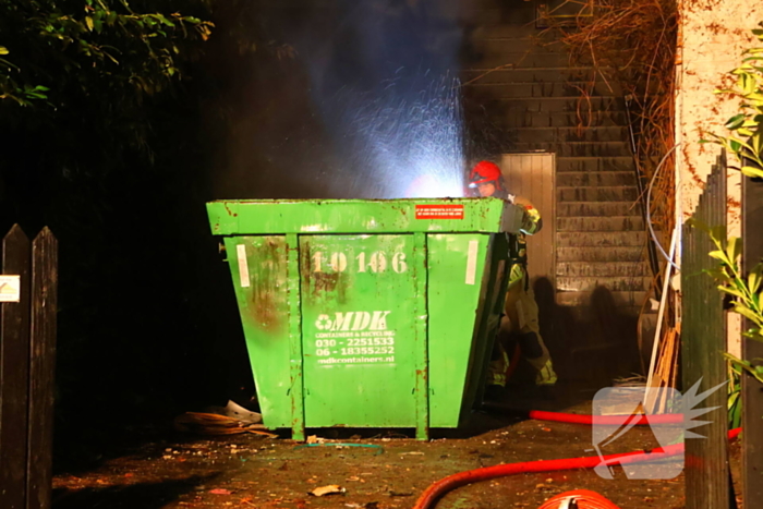 Bouwcontainer vat vlam naast woning met rietendak