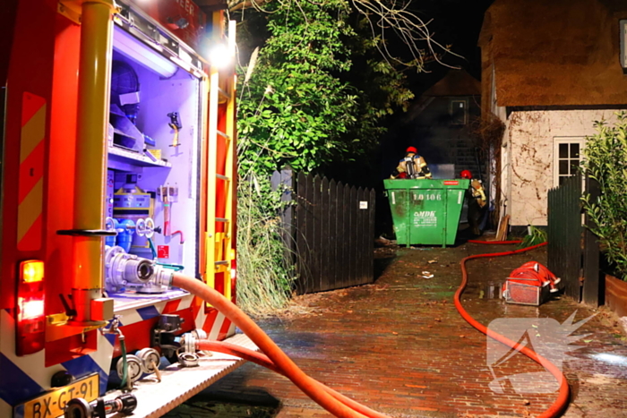 Bouwcontainer vat vlam naast woning met rietendak