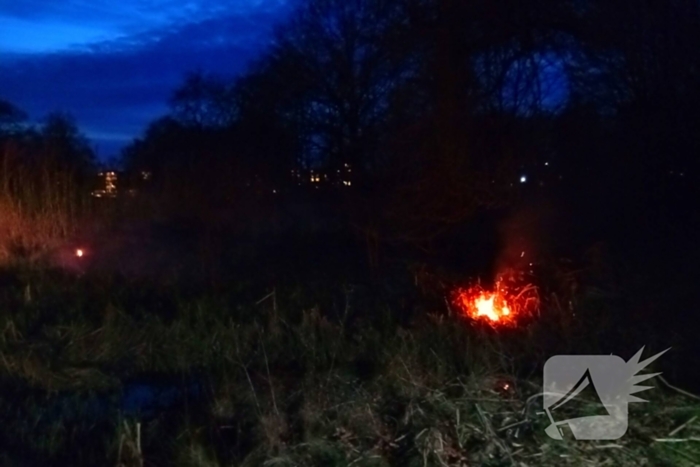 Brandweer blust brandend riet