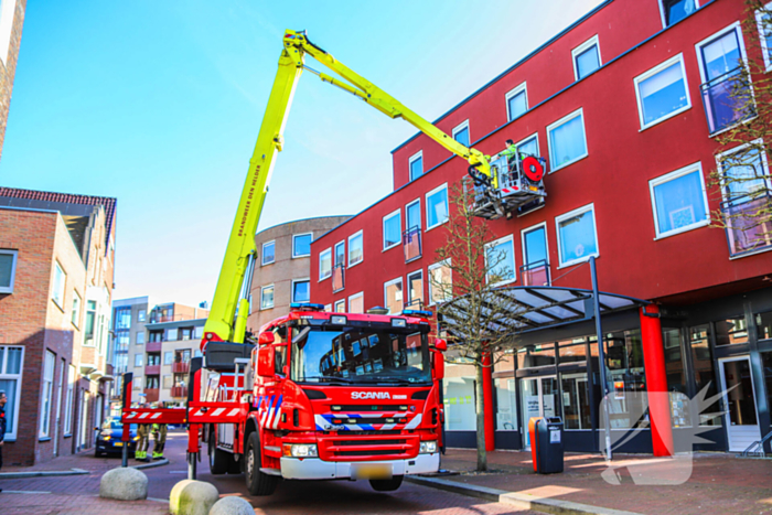 Duif gered uit benarde positie achter glazen balustrade